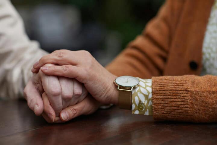 a close up of two hands embracing one another in comfort